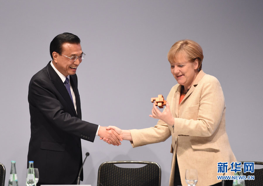 10月10日，中国国务院总理李克强在柏林与德国总理默克尔共同出席第七届中德经济技术合作论坛。这是在论坛上，李克强总理将一精巧的鲁班锁送给默克尔。新华社记者 李学仁 摄 